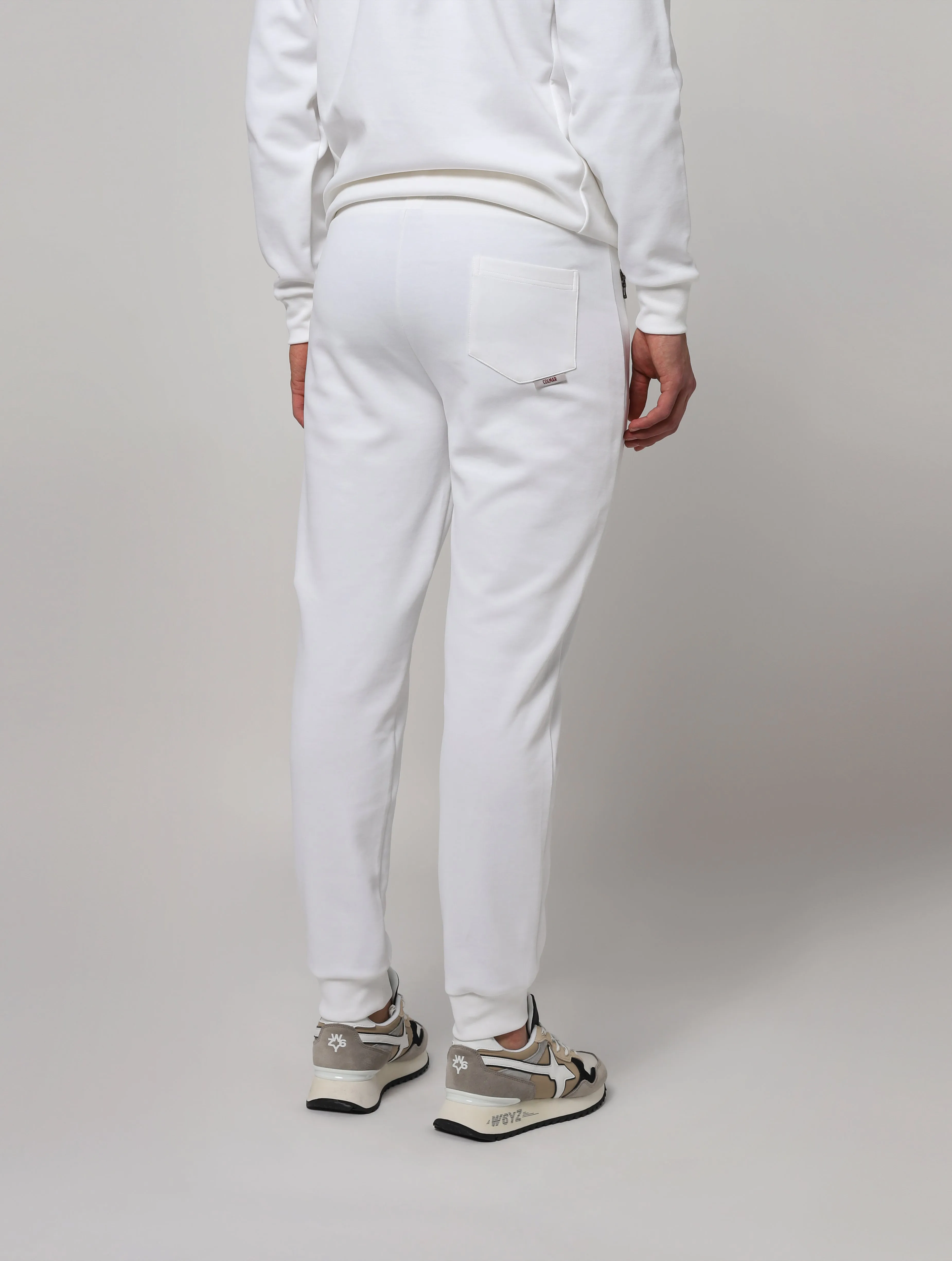 Pantaloni elasticizzati in vita, in maglia a costine con coulisse di regolazione tasche laterali con zip. Taschino posteriore, f